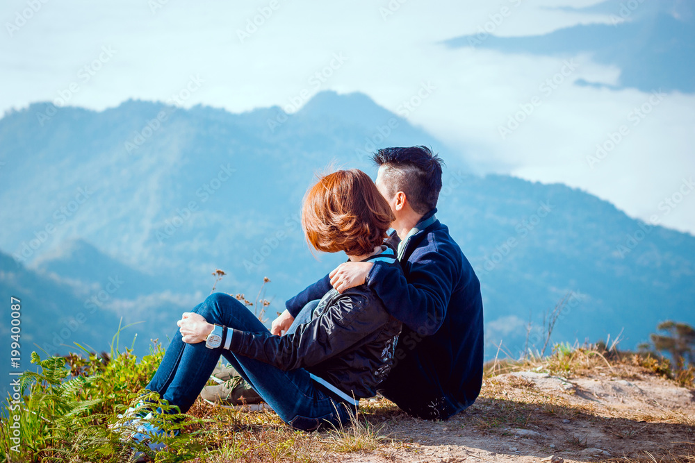 Couple man and woman sitting on top of mountain