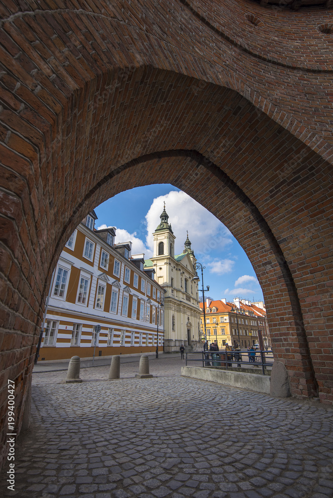 View to The Church of the Holy Spirit in Warsaw from the arch of the Barbican. The church was built in the Gothic style in the early 18th century in Warsaw, Poland