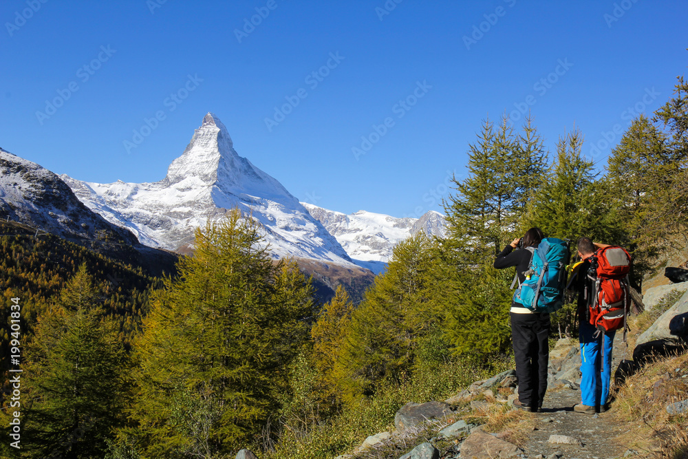Hiker are photographing Matterhorn, the famous Alps peak in Switzerland
