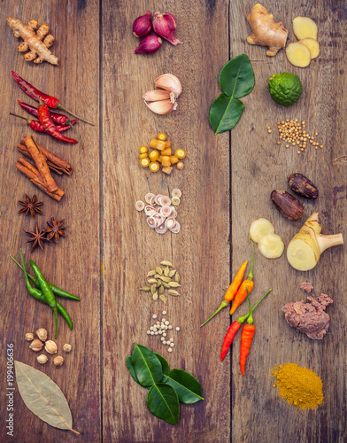 Fototapeta Naklejka Na Ścianę i Meble -  Various of Thai food Cooking ingredients and spice red curry paste ingredient of thai popular food on rustic wooden background. Spices ingredients chilli ,pepper, garlic and Kaffir lime leaves .