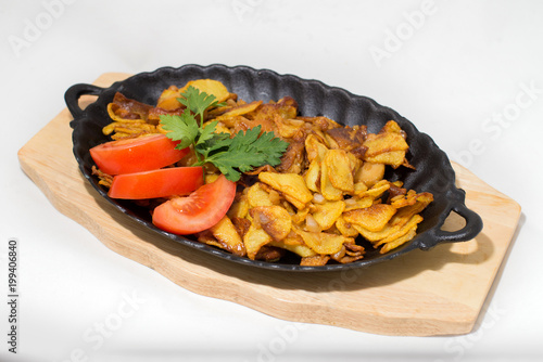 potatoes fried meat in a frying pan on a tree on a white background