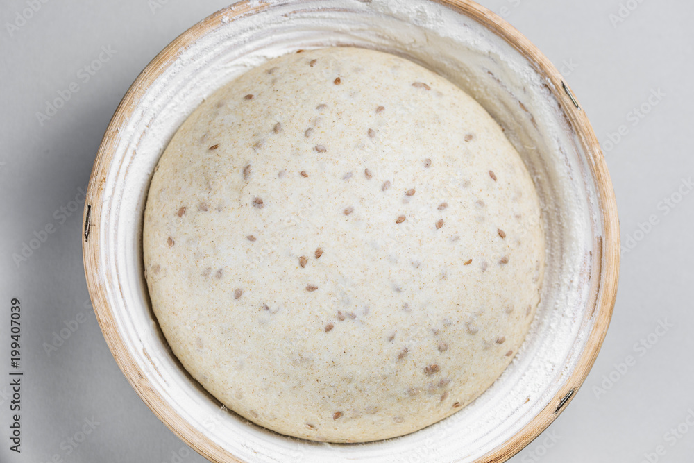 Dough with natural leaven with flax seeds in a rattan basket. The concept of a healthy diet. The style of life. Dough with natural leaven with flax seeds in a rattan basket. The concept of a healthy diet. The style of life.
