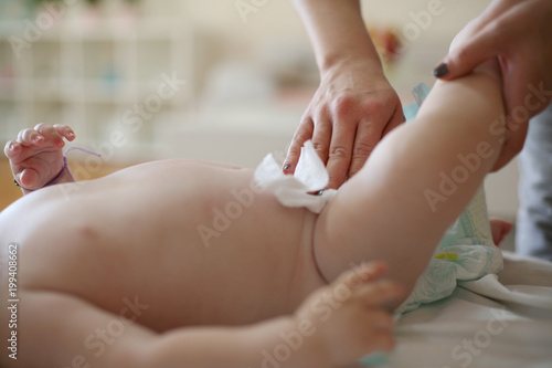 Mother changing diaper baby boy. Close up
