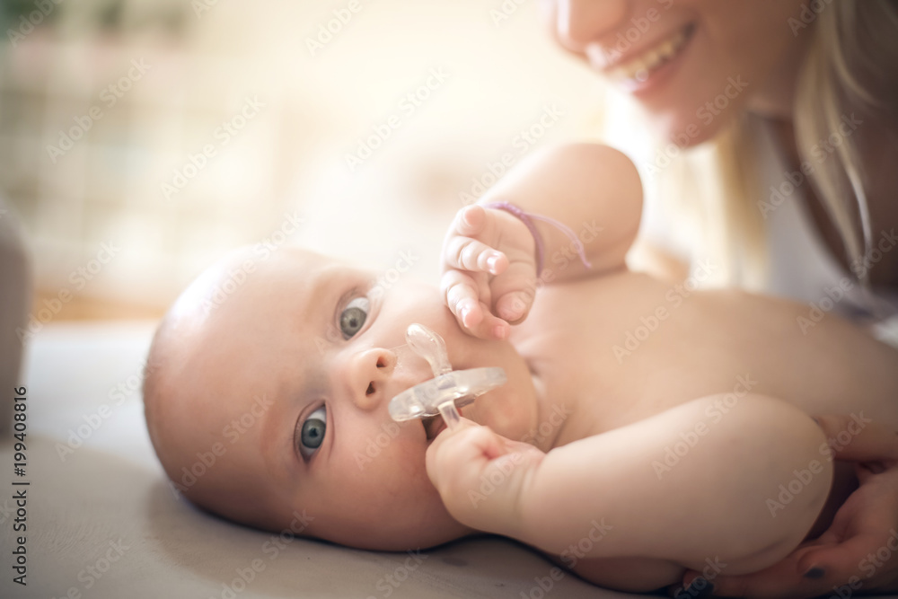 Mother with her baby boy at home. Close up.