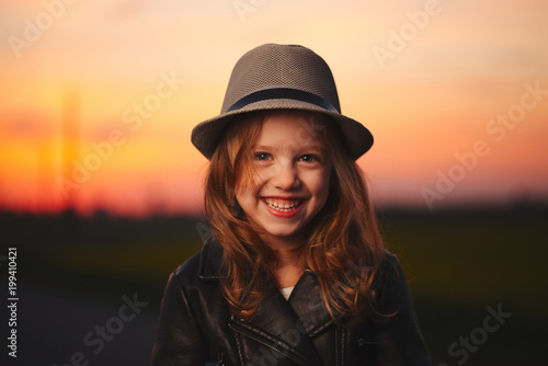 beautiful girl with hat on evening sunset