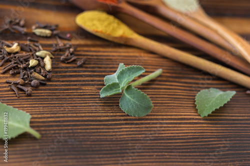 Mint and various spices on a wooden table
