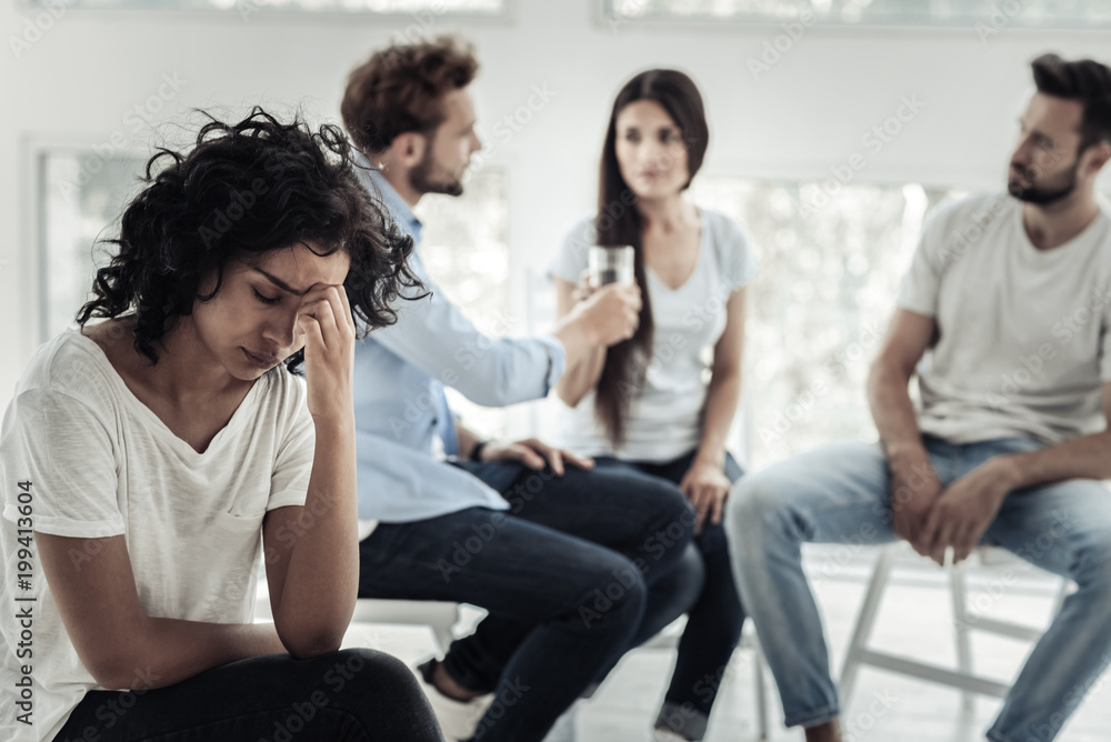So sad. Depressed nice young woman holding her forehead and thinking about her problems while having a depression So sad. Depressed nice young woman holding her forehead and thinking about her problems while having a depression