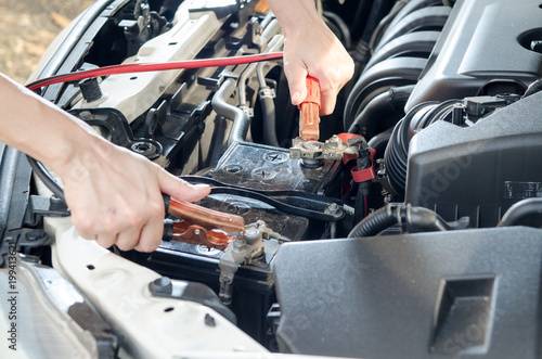 Close up hand charing car battery. depth of field