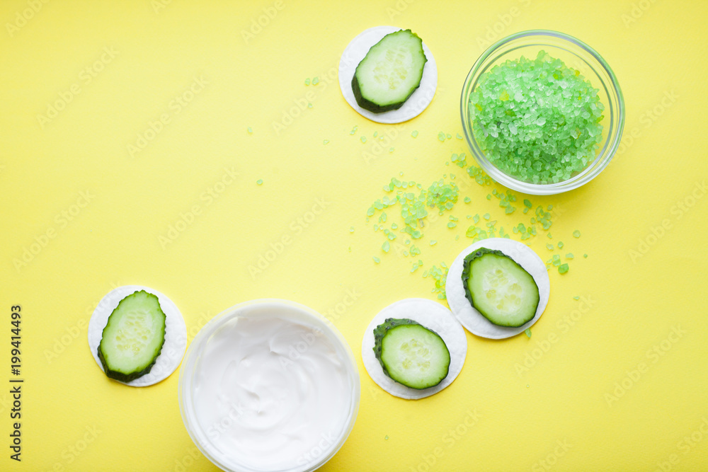 Skin treatment with cucumber and green sea salt on the yellow background. Space for your text. Top view. Skin treatment with cucumber and green sea salt on the yellow background. Space for your text. Top view.