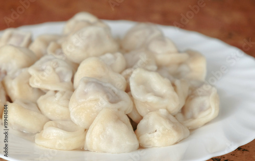 Dumplings on a plate on wooden table.