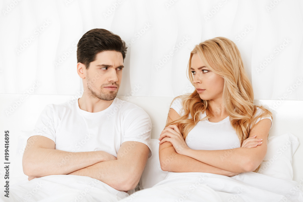 Angry loving couple lies in bed indoors at home quarrel. Angry loving couple lies in bed indoors at home quarrel.