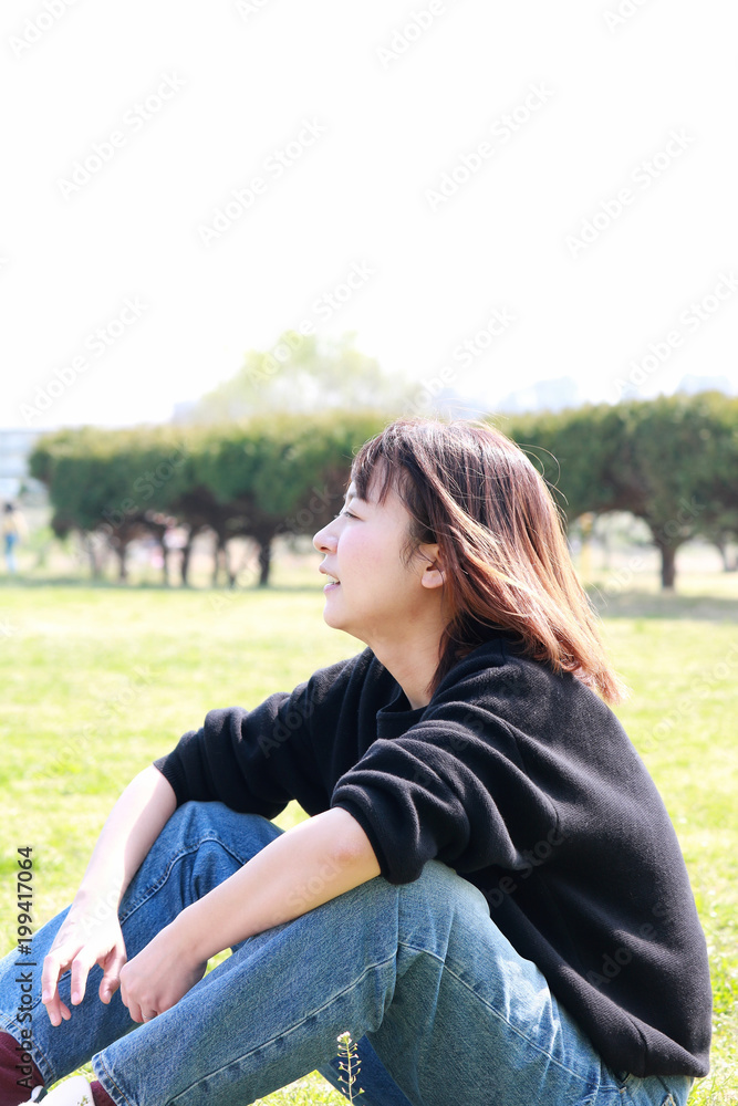 Fototapeta premium 芝生でリラックスする女性