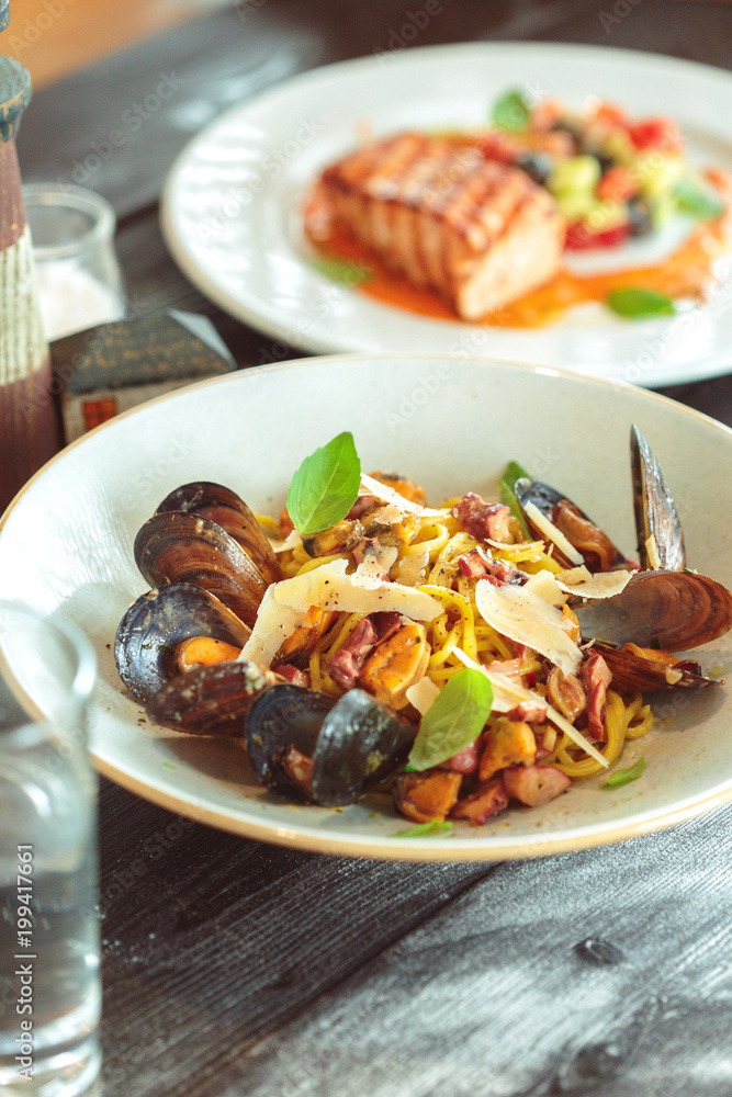Fresh salad with mussels on a wooden table.