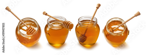 Honey pot with wooden dipper set isolated on white