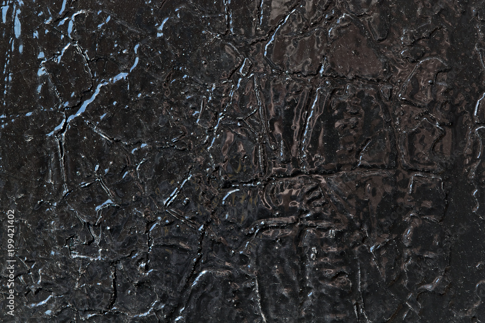 The metal surface is painted with black oil paint. Under paint the bottom layer of cracked old paint. Cracks in the form of lines and bumps of different shapes. The metal surface is painted with black oil paint. Under paint the bottom layer of cracked old paint. Cracks in the form of lines and bumps of different shapes.