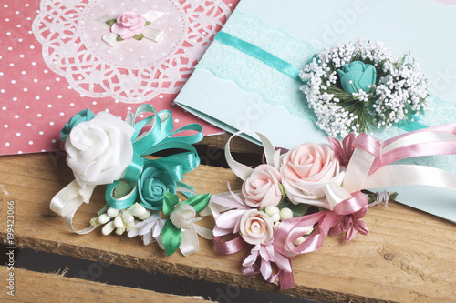 Wedding decor. IInvitation cards and Boutonniere groom with the bride, lie on a wooden box. photo