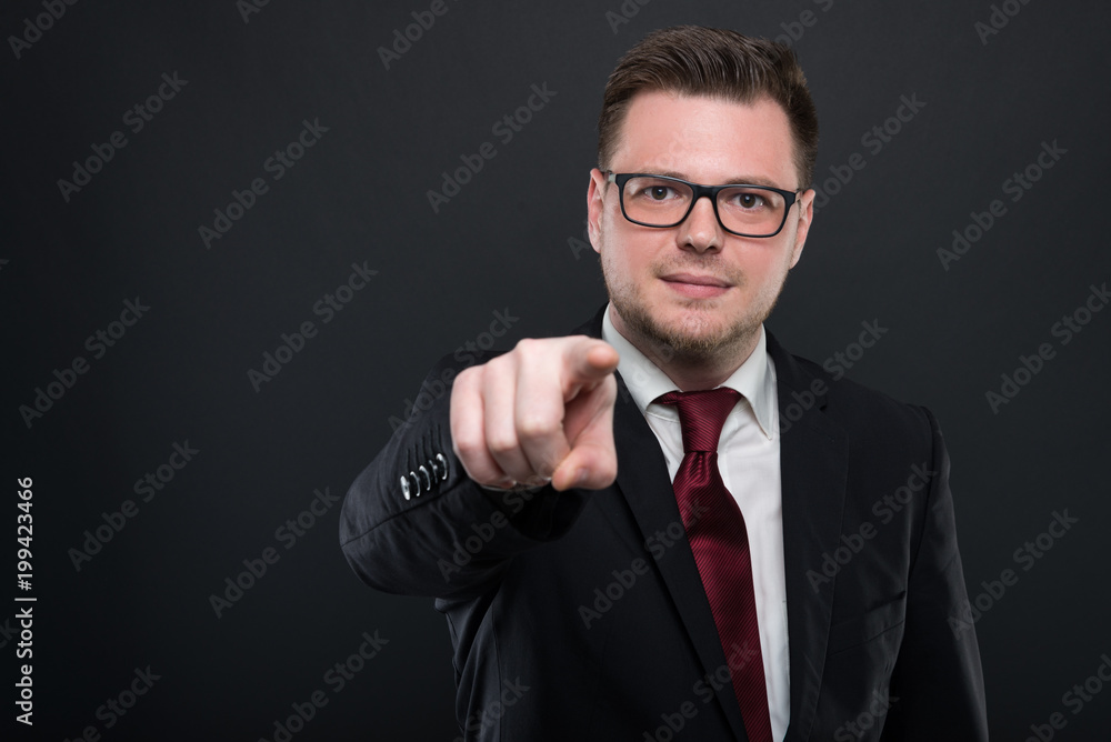 Portrait of business man wearing black suit pointing camera. Portrait of business man wearing black suit pointing camera.