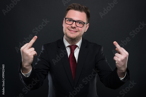 Business man wearing black suit showing double obscene gesture.