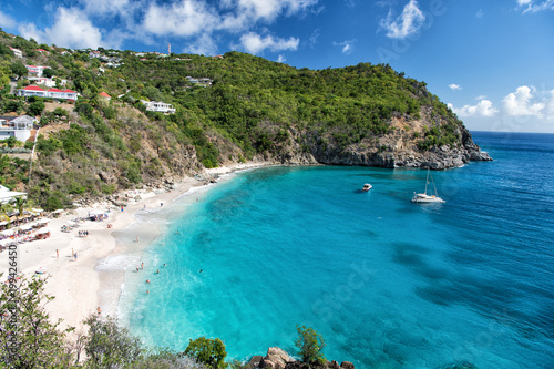 Harbor with sand beach, blue sea and mountain landscape in gustavia, st.barts. Summer vacation on tropical beach. Recreation, leisure and relax concept. Wanderlust and travel with adventure. photo