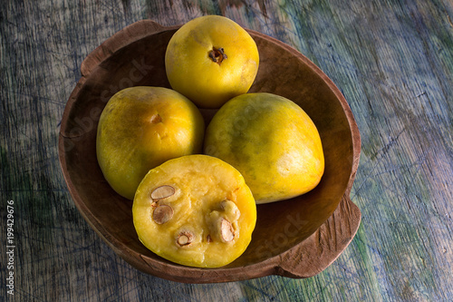rare araza fruits in a wooden bowl on rustic background photo
