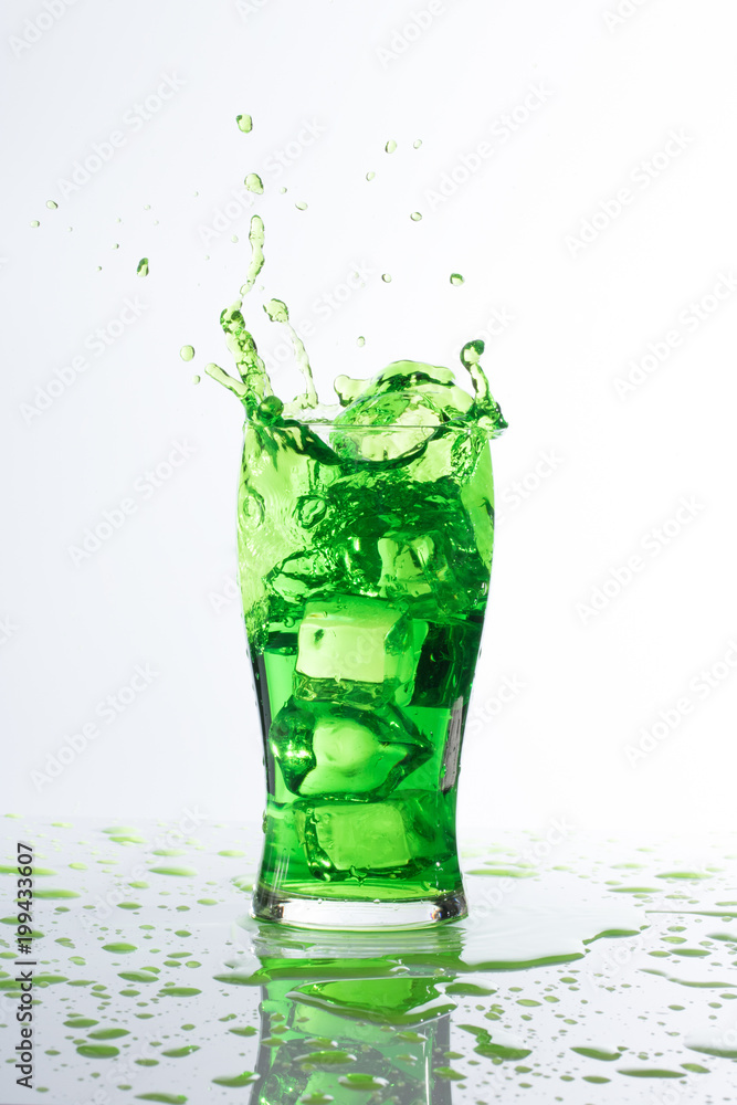 green water ice spalsh in a glass on white background green water ice spalsh in a glass on white background