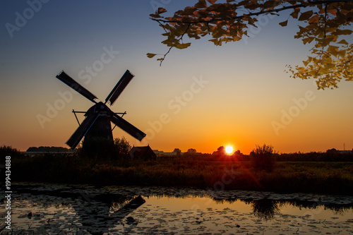 Autumn sunset on the Unesco world heritage site and windmill silhouette under a calm tree shade, Alblasserdam, Netherlands