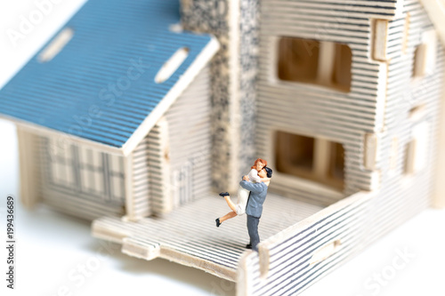 Miniature couple : Couple looking at their dream house on white background © Sirichai Puangsuwan