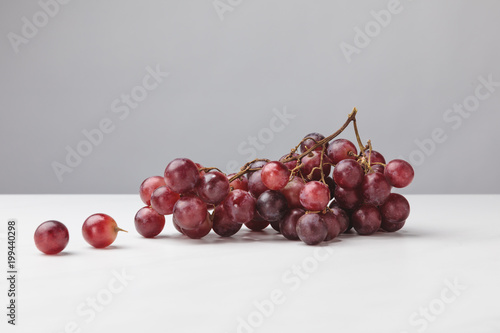 Close up view of pile of red grapes on gray