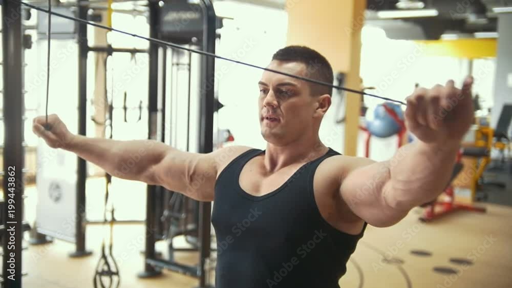 Strong bodybuilder exercising at the bright gym Strong bodybuilder exercising at the bright gym