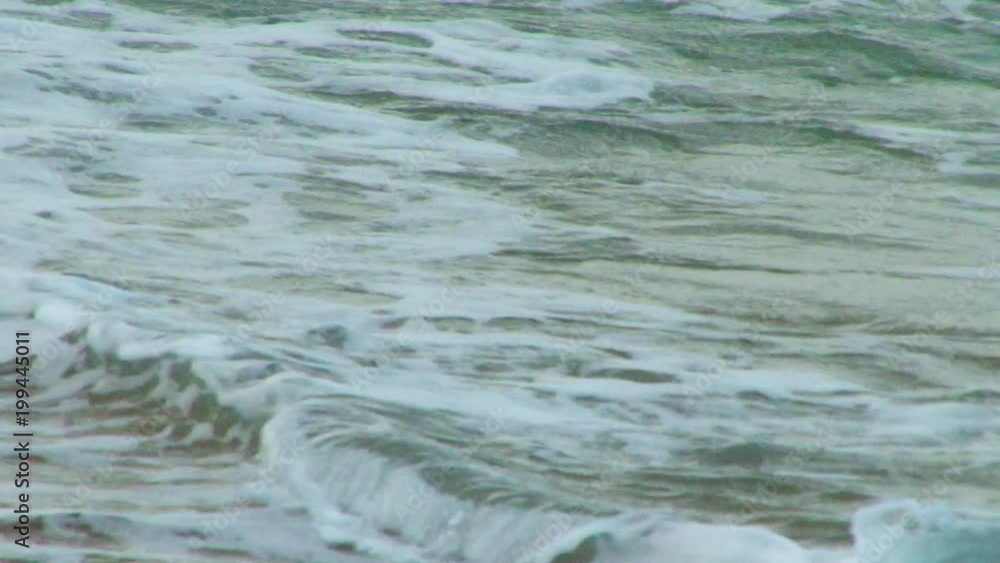 Close up of waves rolling in on a sandy beach Close up of waves rolling in on a sandy beach