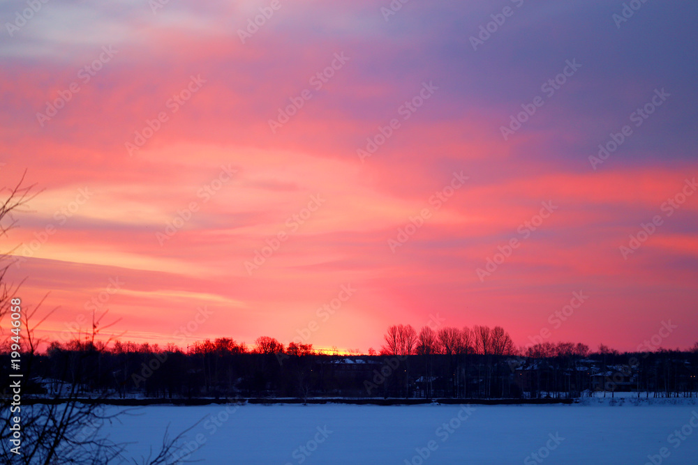 Photo of a bright red dawn over the river