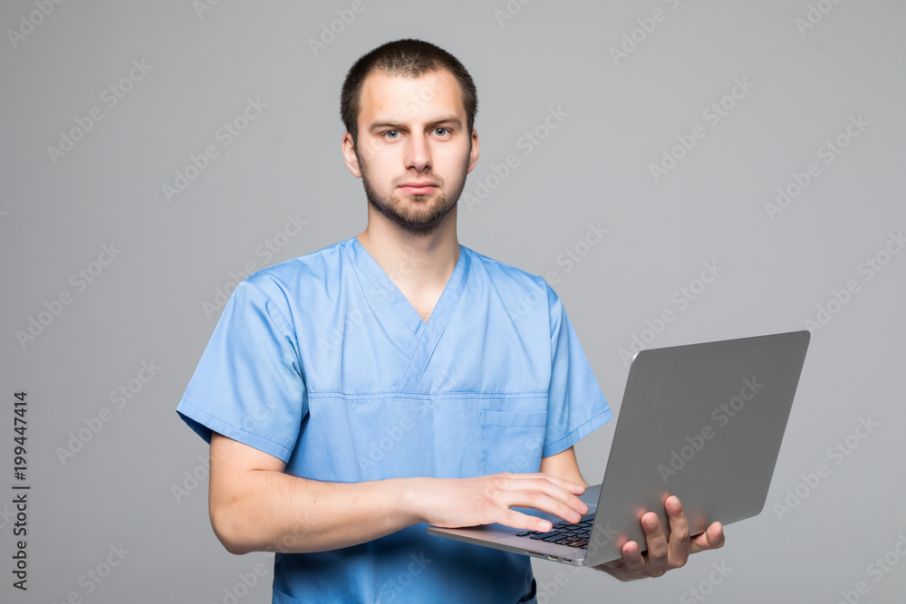 The doctor staring on the laptop isolated on gray background The doctor staring on the laptop isolated on gray background