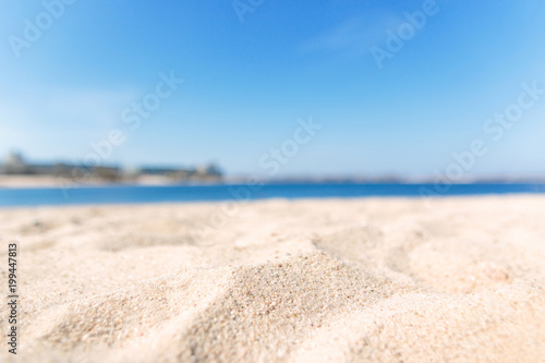 Close up sand with blurred sea sky background, summer day, copy space or for product