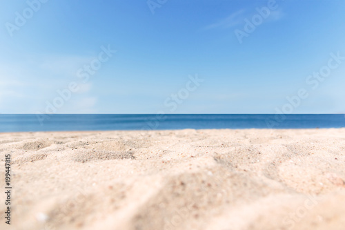 Close up sand with blurred sea sky background, summer day, copy space or for product