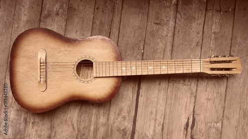 old acoustic guitar on a wooden background photo
