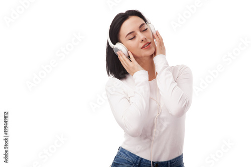 Young beautiful woman enjoying with listening the music in big headphones © Amelia Fox