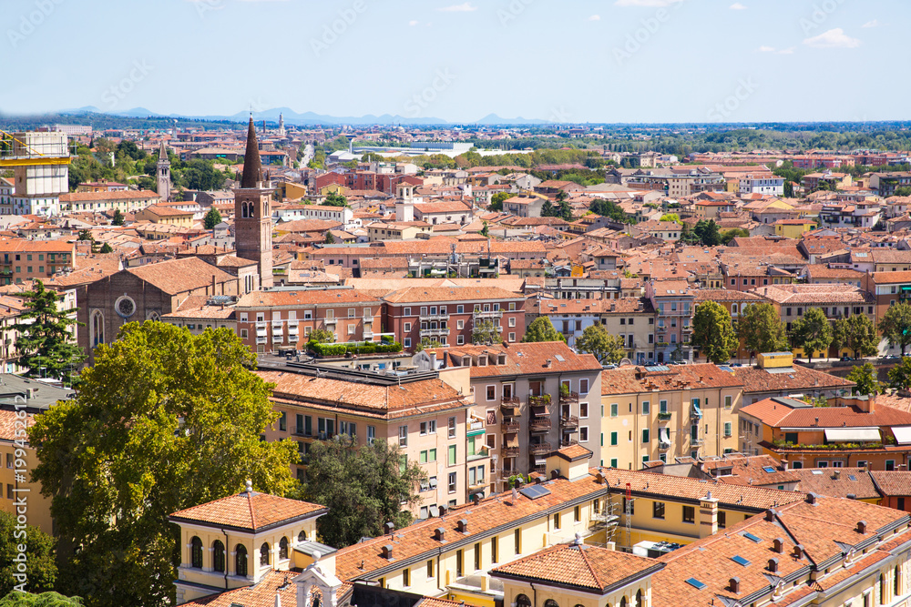 Fototapeta premium Panoramic cityscape of Verona, Veneto, Italy. Orange tiling medieval roofs. Bright sunny summer day.