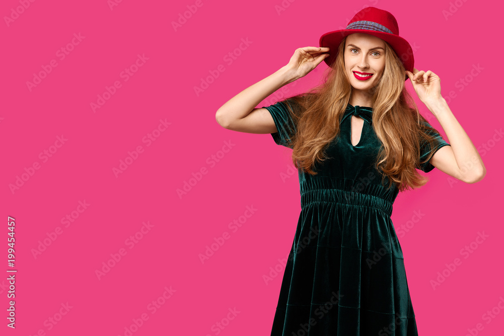 Young beautiful woman on a pink background in a green dress and hat. Concept of healthy nutrition and sports. Colour obsession concept. Minimalistic style. Stylish Trendy Young beautiful woman on a pink background in a green dress and hat. Concept of healthy nutrition and sports. Colour obsession concept. Minimalistic style. Stylish Trendy