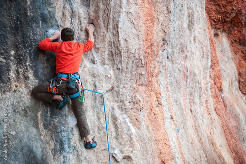 Fototapeta Naklejka Na Ścianę i Meble -  A man climbs the rock.