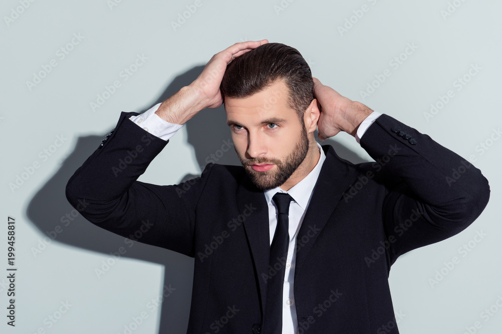 Stunning, perfect, manly, virile, harsh guy in classic outfit holding two hands on head, looking to the side with serious expression, isolated on grey background Stunning, perfect, manly, virile, harsh guy in classic outfit holding two hands on head, looking to the side with serious expression, isolated on grey background