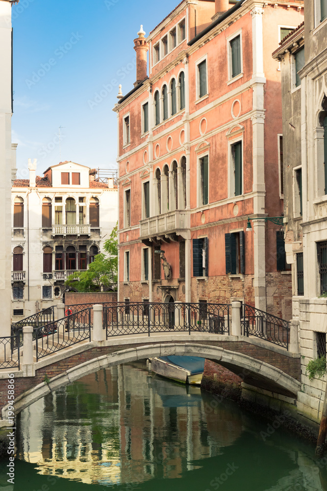 Walk through the charming, narrow streets of Venice, typical but magical view - canals, bridges and old tenements with green shutters