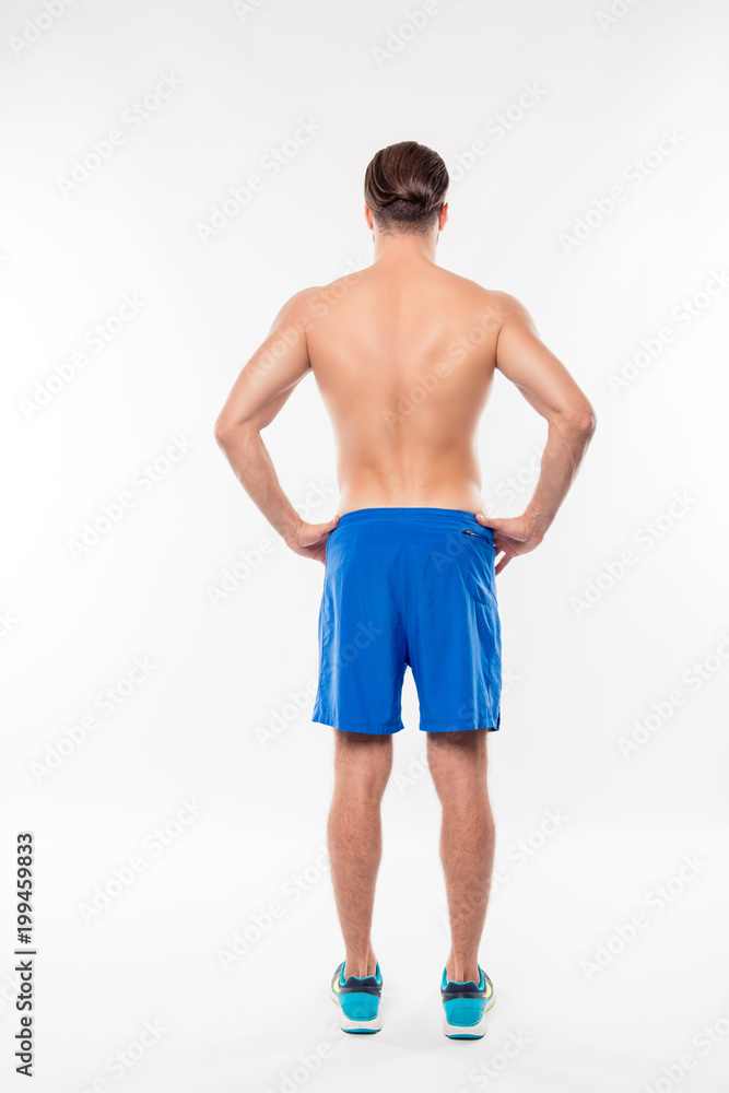 Foto Stock Fullbody back side view portrait of athletic, sportive man  holding hands on waist, having modern hairstyle and perfect, relief body,  standing on white background | Adobe Stock