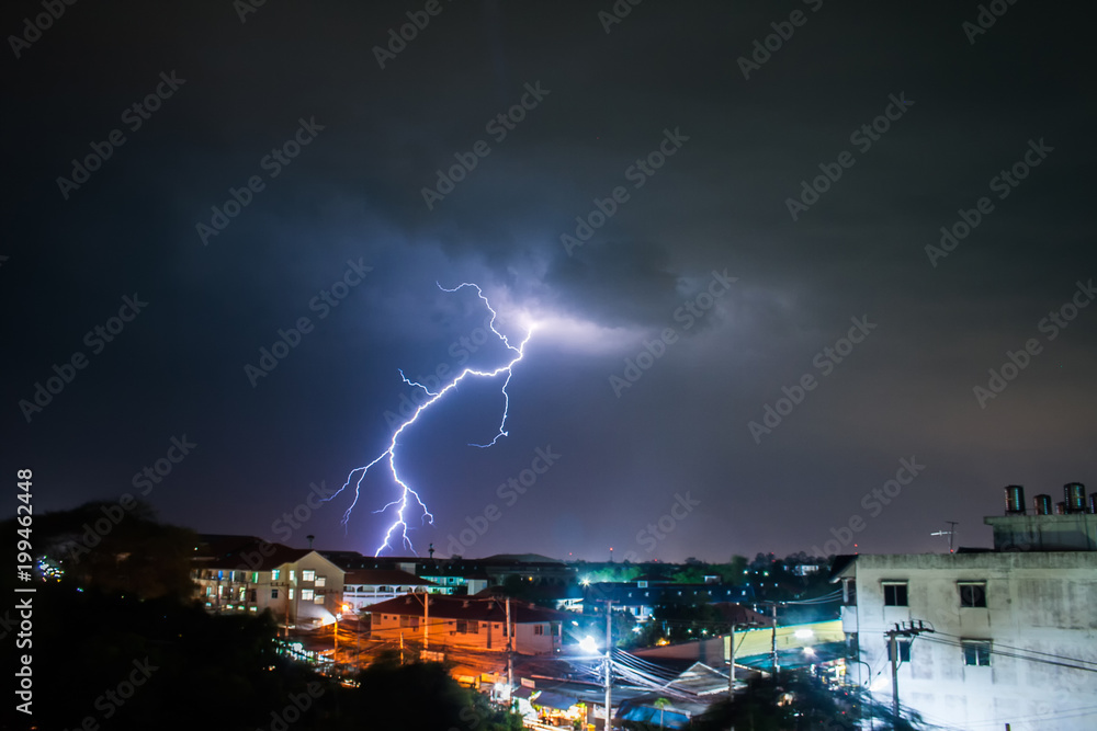 Heavy storm at night with dramatic clouds and thunderbolt lightning to the city.