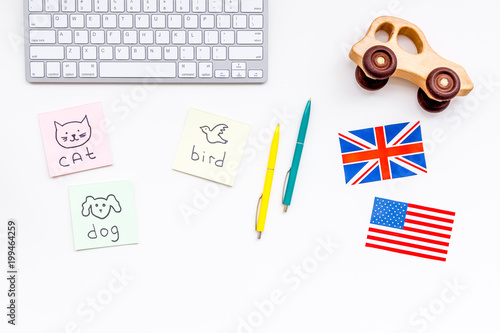 English for children. British and american flags, computer keyboard, stickers with vocabulary, toy on white background top view copy space © 9dreamstudio