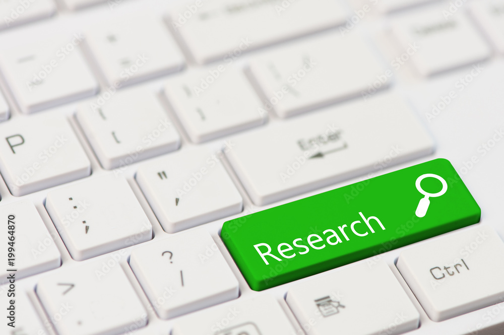 A green key with Research text on white laptop keyboard A green key with Research text on white laptop keyboard