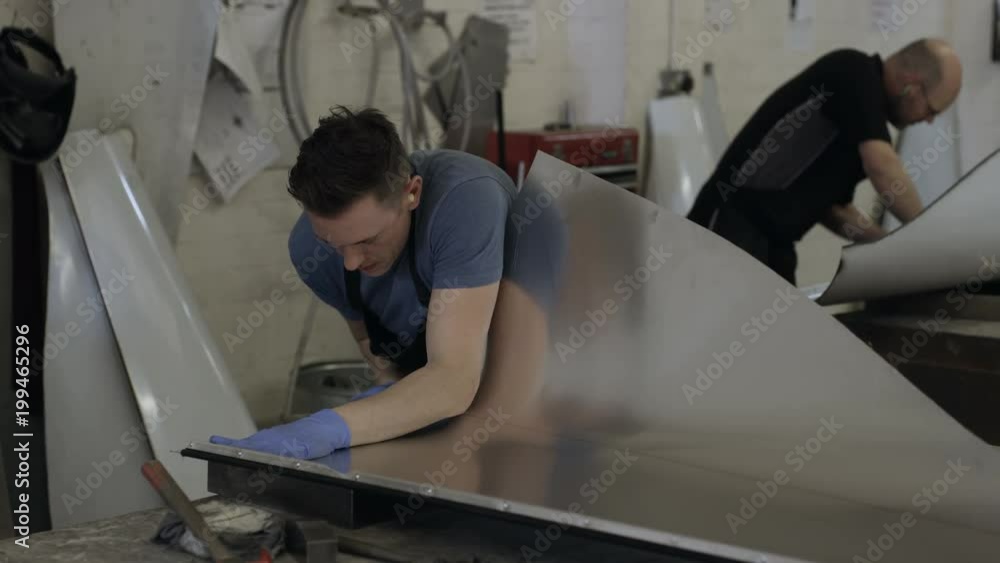 Car manufacturing plant engineers working on vehicles Car manufacturing plant engineers working on vehicles