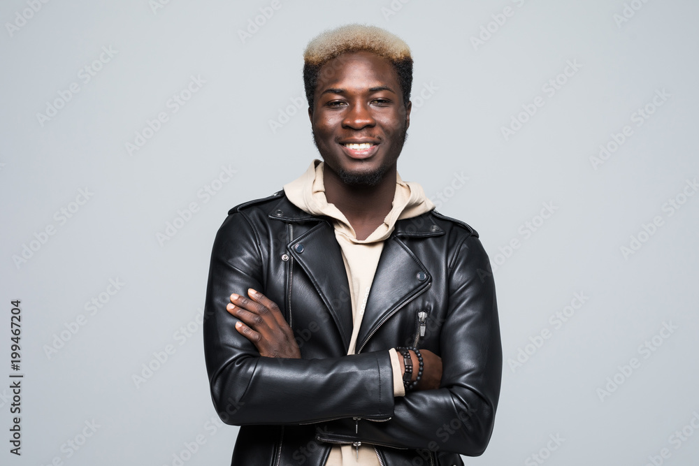Portrait of young funny dark-skinned man with arms crossed with afro hairstyle in casual shirt isolated on gray Portrait of young funny dark-skinned man with arms crossed with afro hairstyle in casual shirt isolated on gray