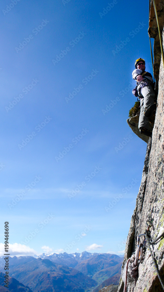 Fototapeta premium mountain guide rock climber on a steep granite route in the Alps of Switzerland on a beautiful day