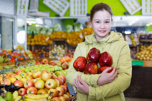 Smiling girl holding ripe red apples