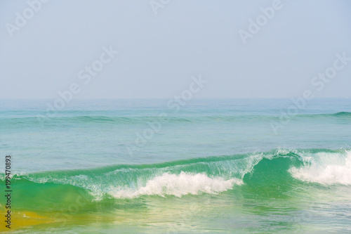Blue waves of the ocean and yellow sand of the beach.